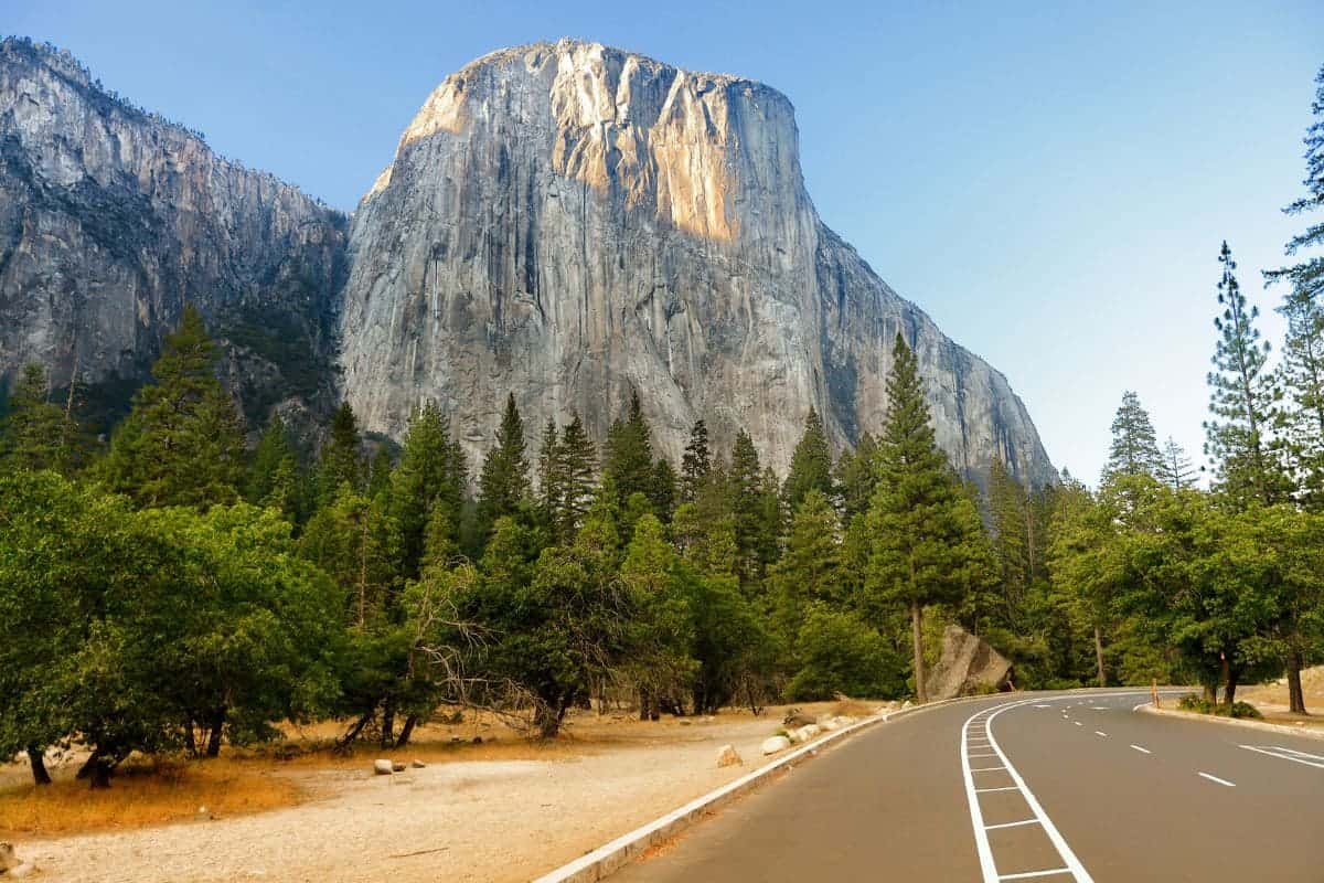 El Capitan mountain formation and road through Yosemite National Park USA. Road trip in mountain landscape in California showing forest and mountains at sunset in summer.