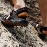 Guy climbs on rock mountains on his hiking sandals.