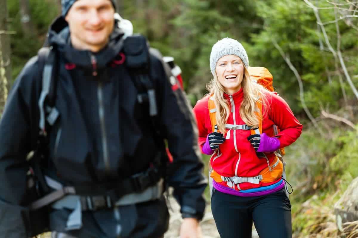 Couple happy hikers walking in mountains